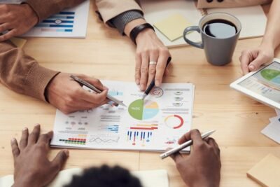 Na imagem, grupo em reunião analisando gráficos de estratégia de marketing de afiliados