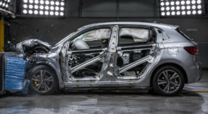 Veículo em teste de colisão mostrando deformação controlada da estrutura e absorção de impacto, destacando a importância da segurança estrutural automotiva na proteção dos ocupantes.